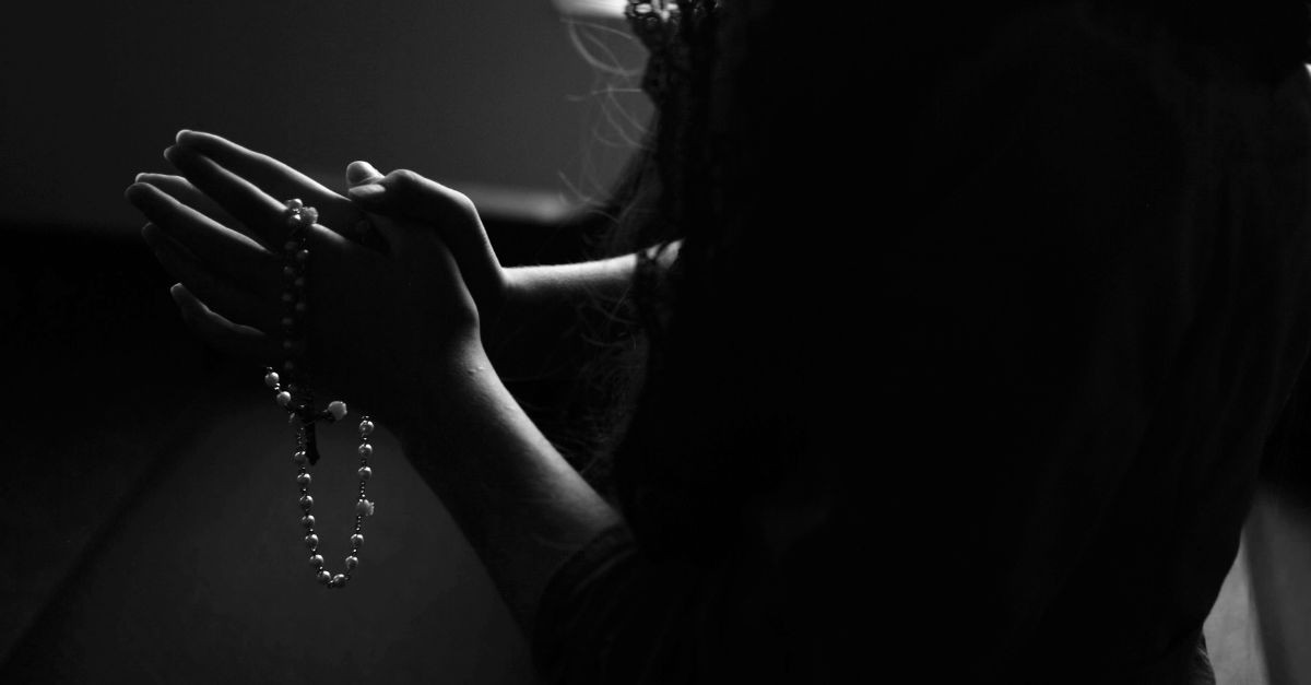 Woman praying in church; why do Christians pray?